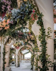 an archway covered in flowers and greenery