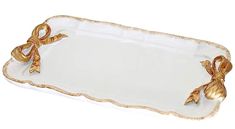 a white and gold serving tray with bows on the handles is shown in front of a white background