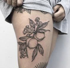 a woman's thigh with fruit and flowers on it