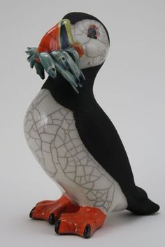 a figurine of a black and white bird with an orange beak