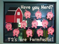 a window display with pink pigs in front of a barn and text have you herd?