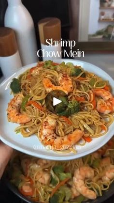 shrimp chow mein with broccoli and carrots on a white plate