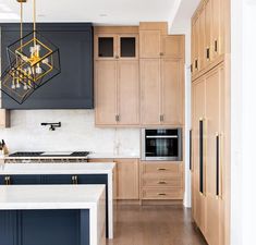 a modern kitchen with blue cabinets and white counter tops, an island in the middle