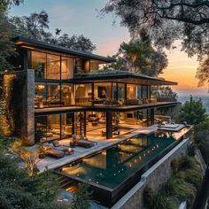 the house is surrounded by trees and overlooking the ocean at sunset or sunrise, it's very nice to see