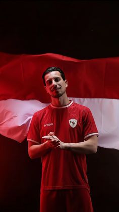 a man with his face painted like a soccer player standing in front of a flag