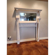 a white fireplace with a mirror above it