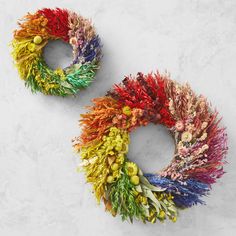 two wreaths made out of different colors of yarn on a white surface with space for text