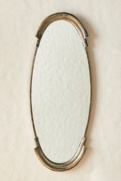 an oval mirror hanging on the wall