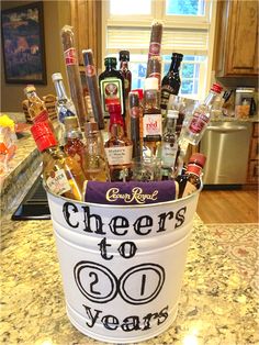 a bucket filled with liquor bottles and condiments sitting on top of a counter