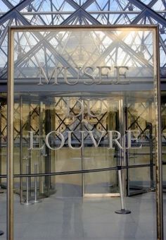 an entrance to a museum with the words museum on it's glass door and metal frame