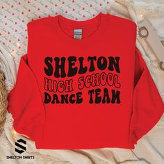 Shelton High School Dance Team Wavy Font Shirt Show off your school spirit with this stylish Shelton High School Dance Team Wavy Font Shirt! It's the perfect outfit for joining the crowd to cheer on the school's amazing dancing talents! Shout out to our dance team! Choose T-shirt, Crewneck Sweatshirt or Hoodie Sweatshirt. Super comfy unisex sizes. Our shirts, hoodies, and sweatshirts are crafted with comfort and quality in mind. Made from premium materials, they are soft, durable, and perfect fo Drill Team Shirts Design, School Spirit T-shirt For Cheerleading In Fall, Dance Team Tshirt Designs, School Dance Team Shirts, Long Sleeve Cotton Top For School Events, Long Sleeve Cotton Tops For School, Cotton Long Sleeve Tops For School Events, School Spirit Stretch Tops For Cheerleading, Team Spirit Long Sleeve Tops For School