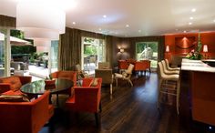 a living room filled with lots of furniture next to a dining room table and chairs