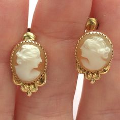 Hand carved genuine shell vintage cameo earrings set in bezel settings have screw backs. These are perfect for non-pierced ears and can be also be easily worn by those with pierced ears. Shiny gold fill oval bezels with saw tooth edging sit atop dainty floral bowers. Earrings are 17 mm long by 11 mm wide ovals with a depth of about 5 mm. Screw backs are signed C.T. and marked 1/20 12K G. F. The carvings are nicely done by hand, the women are similar yet interestingly different from one another.