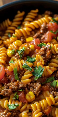 a skillet filled with pasta and meat