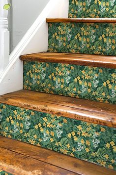 the stairs are decorated with green and yellow floral wallpaper, along with wooden handrails