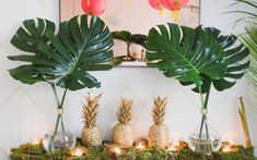 there are pineapples and other decorations on the mantel with candles in front of them