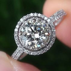 a close up view of a diamond ring on someone's finger