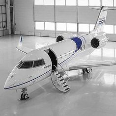 a white and blue jet sitting inside of a hangar