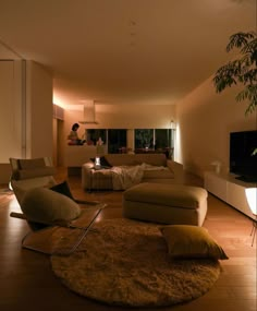 a living room filled with furniture and a flat screen tv on top of a wooden floor