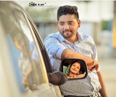 a man taking a photo in the side mirror of a car with a woman looking at him