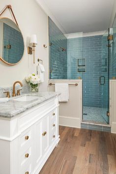 a bathroom with two sinks, a shower and a large mirror on the wall above it