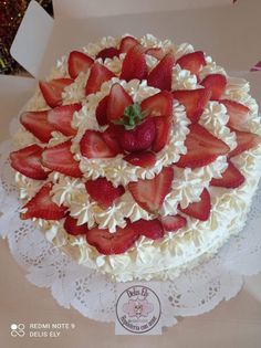 there is a cake with strawberries on the top and white frosting around it