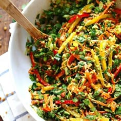 a white bowl filled with colorful vegetables on top of a table