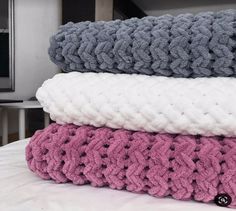 three knitted blankets stacked on top of each other