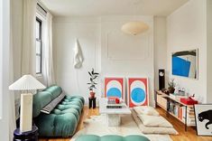 a living room filled with furniture and a painting on the wall next to a window