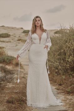 a woman in a wedding dress standing on a path