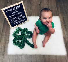 a baby is sitting on a rug next to a shamrock sign and st patrick's day decorations