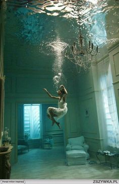 a woman is floating in the air under water