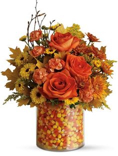 a candy jar filled with orange and yellow flowers