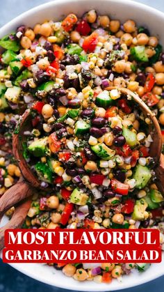 a salad with beans, cucumbers, and other vegetables in a white bowl