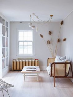 a living room filled with furniture and a window covered in light coming through the windows