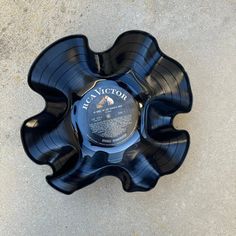 an empty black bowl sitting on top of cement floored area with the word act victory printed on it