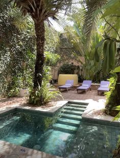 an outdoor swimming pool surrounded by trees and chairs