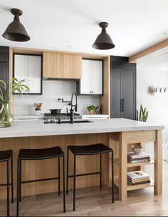 a kitchen with two stools next to an island