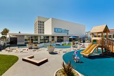 children's play area in front of an office building with playground equipment and toys