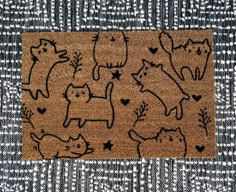 a door mat with cats drawn on it and hearts in the shape of heart shapes