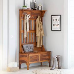 a wooden bench sitting next to a coat rack