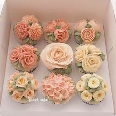 cupcakes decorated with flowers in a box