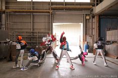 a group of people standing around each other in a warehouse with one person holding their arms up