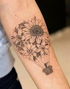 a woman with a tattoo on her arm holding a bouquet of flowers