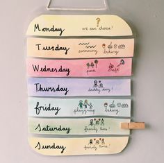 a wooden sign hanging on the side of a wall that has different days and months written on it