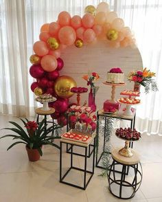 the table is set up with balloons and desserts