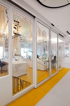 an office with glass walls and yellow carpeting on the floor is pictured in this image