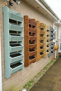 a row of bird houses sitting on the side of a building