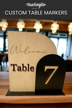 a wooden table with a sign that says, welcome to the tables 7 and 7