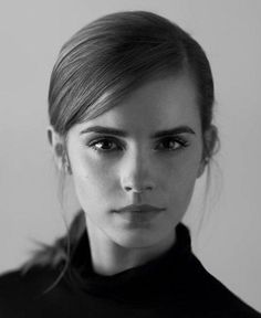 a black and white photo of a woman with her hair in a pony tail bun